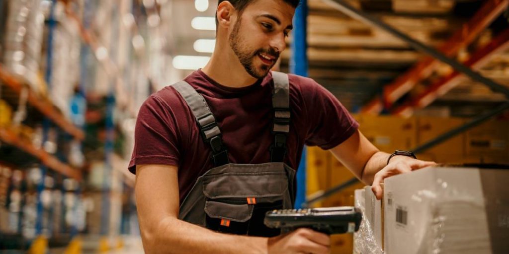 man in warehouse scanning QR code