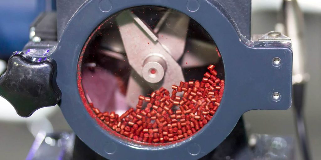 recycled red plastic pellets ready for use in a circular manufacturing model