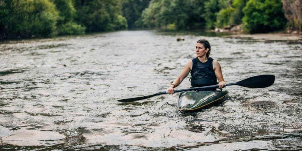 how pim makes the world a better place - a female kayaker surveys a river.