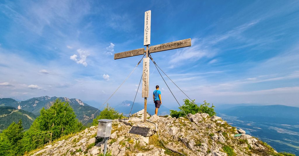 hiker reaching the summit of alpine peak.