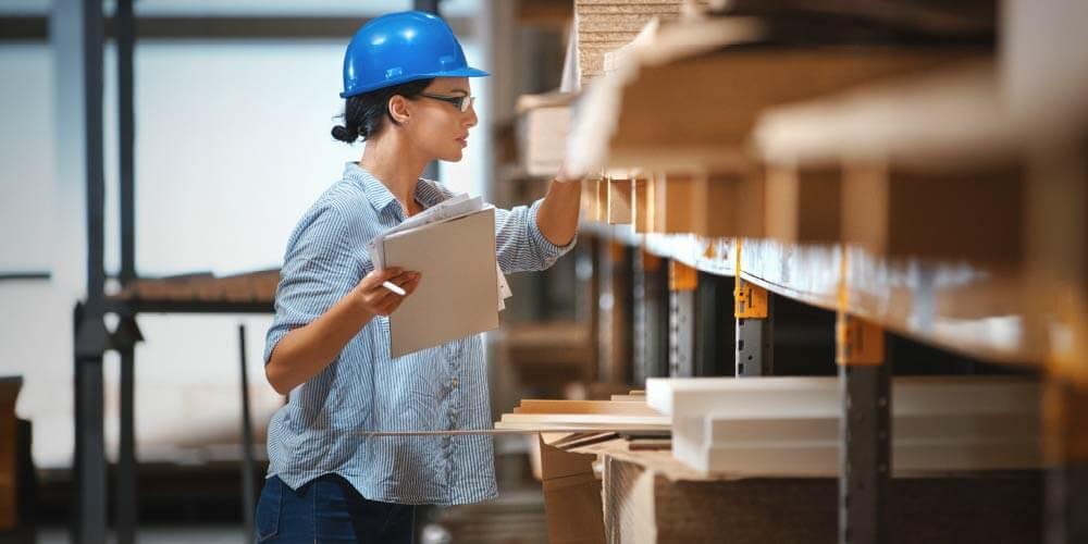female manufacturing worker searching for product in warehouse