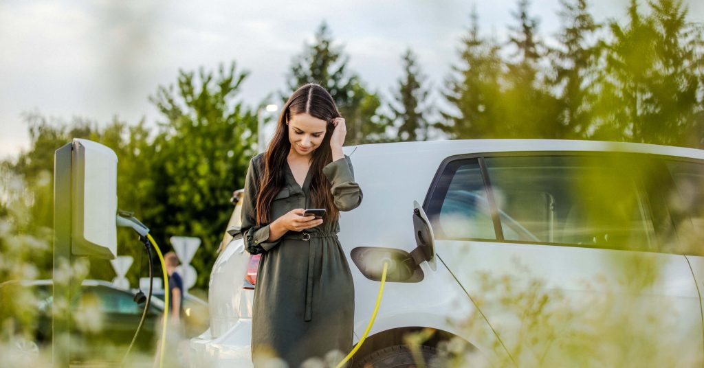 female driver waiting for her electric car to charge