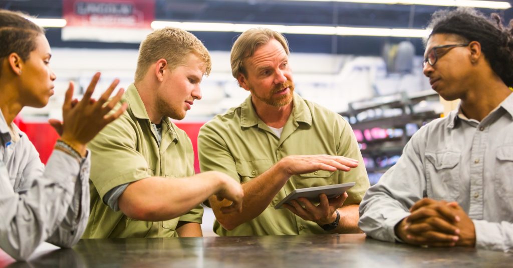 employees talking around tablet