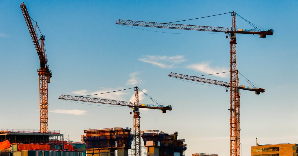 four cranes working on new construction