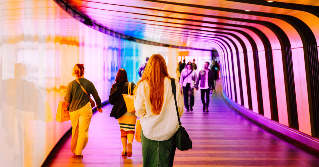 commuters walking through colorful metro tunnel in London, UK