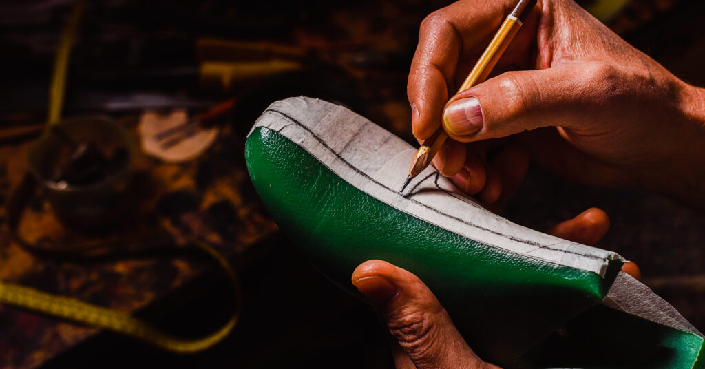 factory worker stenciling handmade sneakers