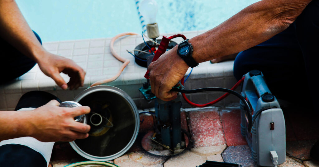 workers maintaining pool filter