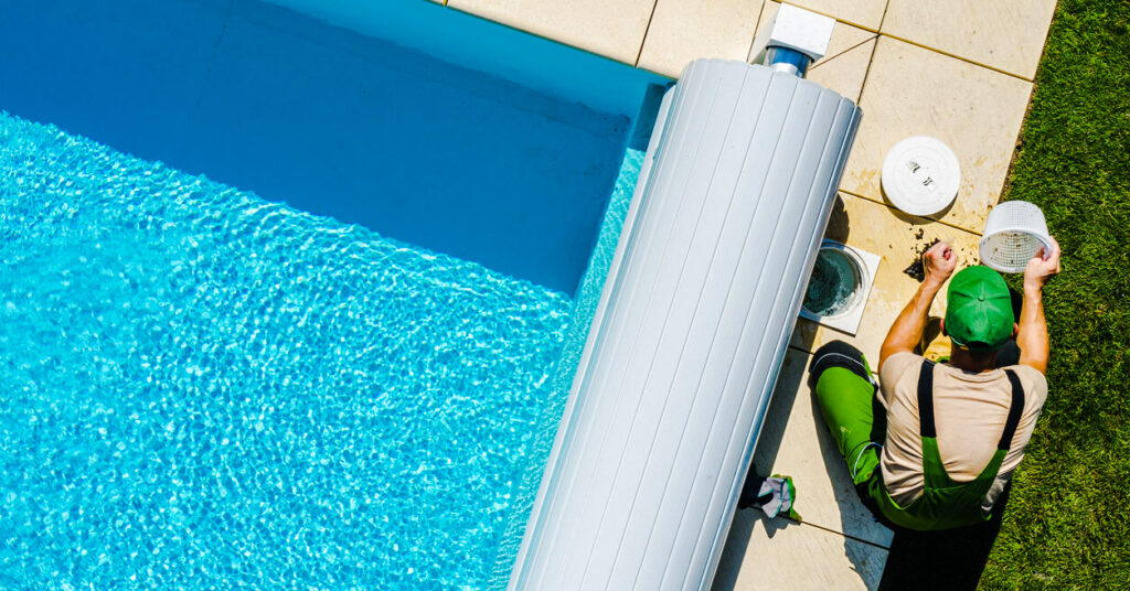 pool worker maintaining the filter on a sunny day