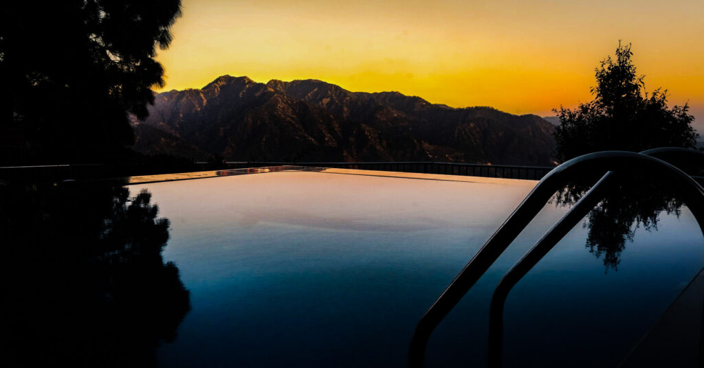 empty swimming pool at sunset with mountains in background
