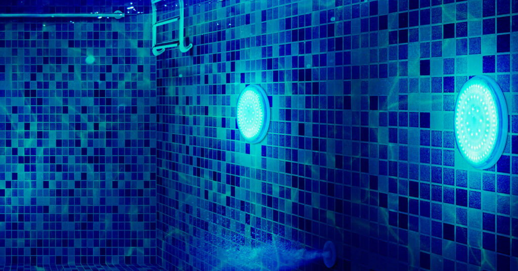 underwater shot of pool lights in tiled swimming pool