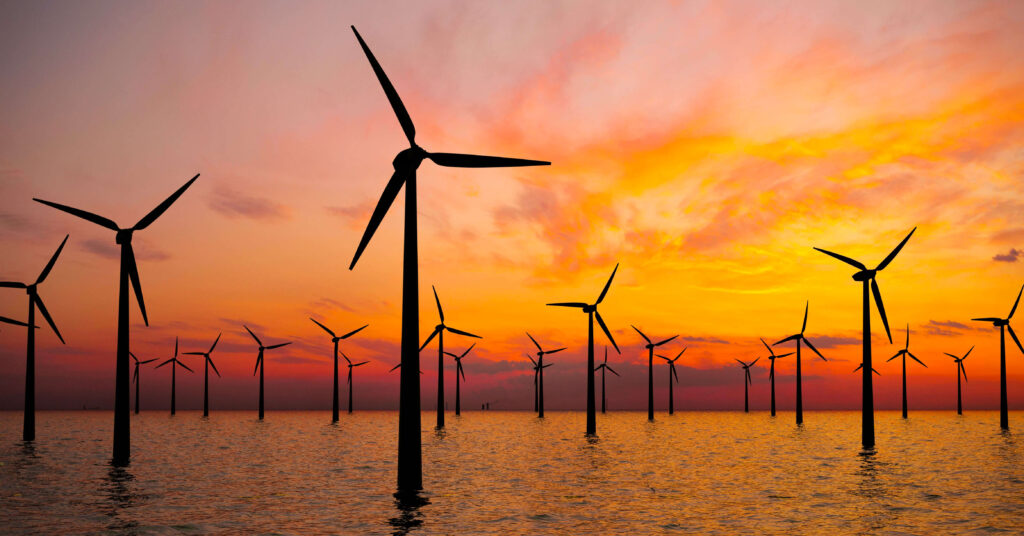 windmills in the sea at sunset