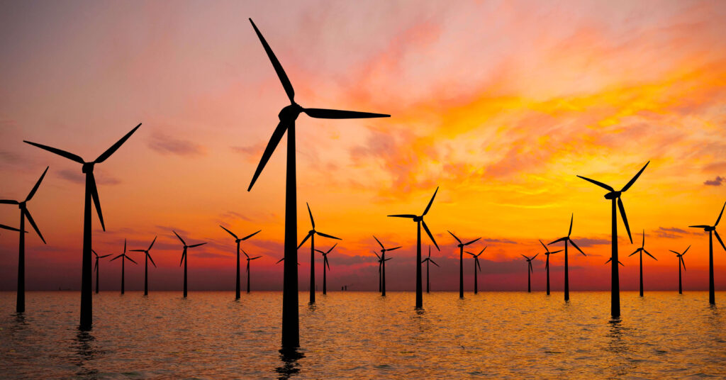 windmills in the sea at sunset