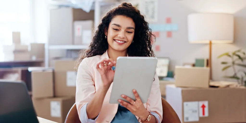 woman sitting using tablet boxes in the background