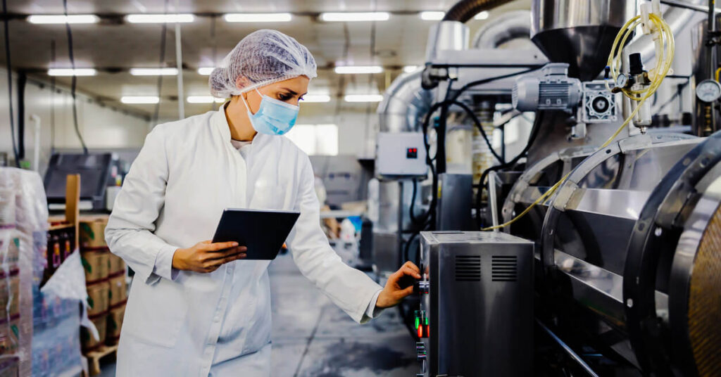 operator in mask and protective wear at dairy