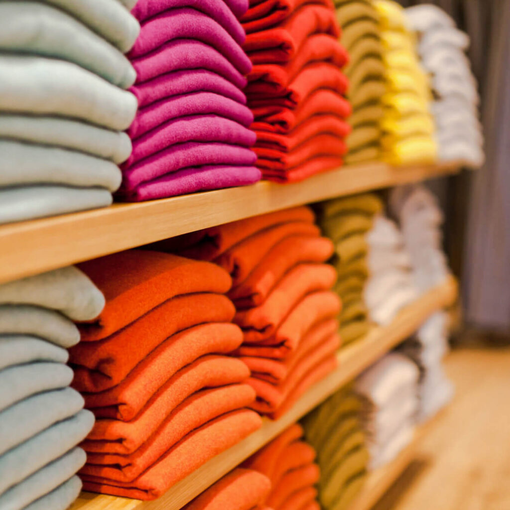 different color sweaters on a shelf