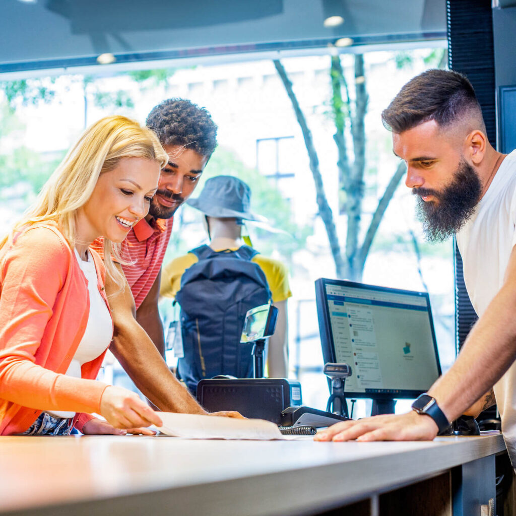 shop assistant serving two customers in biking store