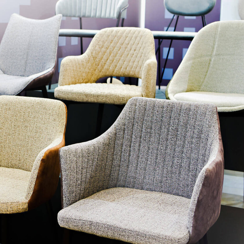 different colored soft furnished chairs lined up in showroom