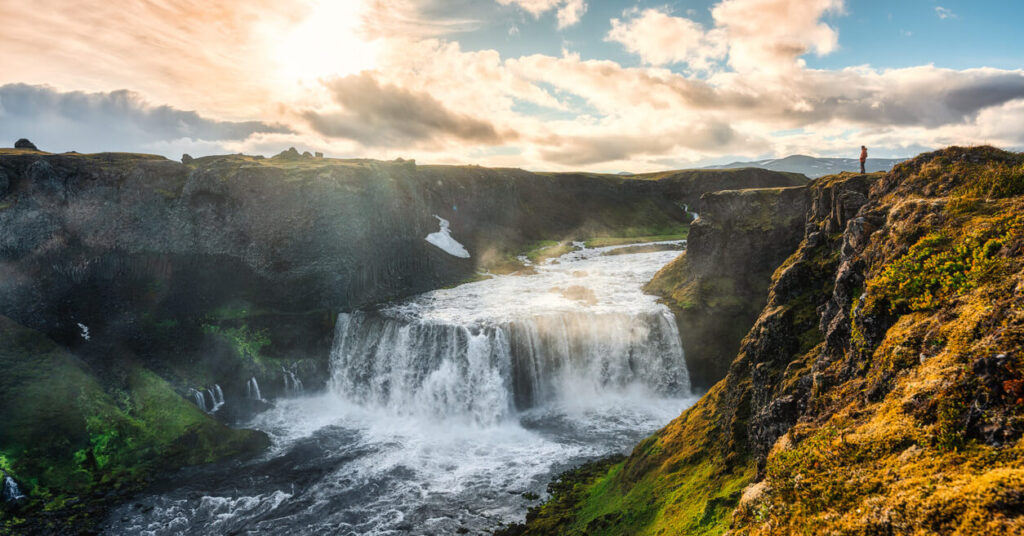 large waterfalls with sunny skies above