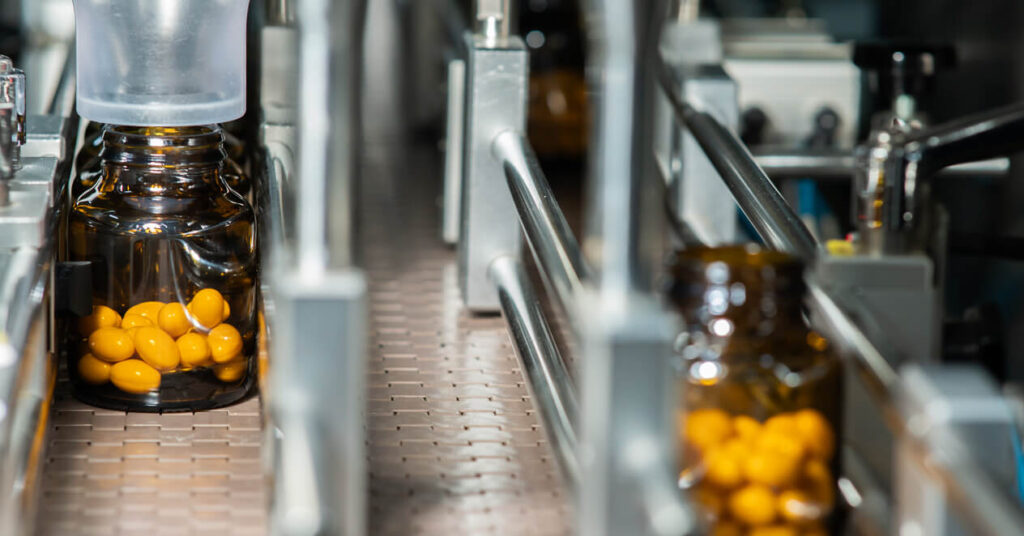 close up of medicine production line showing bottle of pills