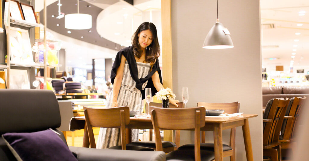 female shopper looking at wooden table in store