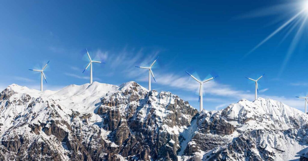 group of wind turbines on mountain ridge snowy atmosphere