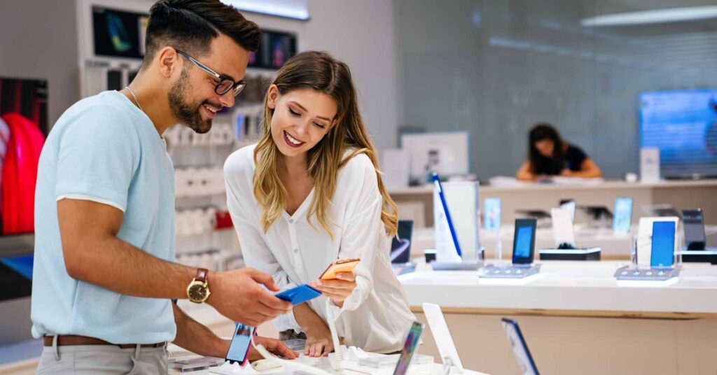 couple shopping for smartphones in retail store