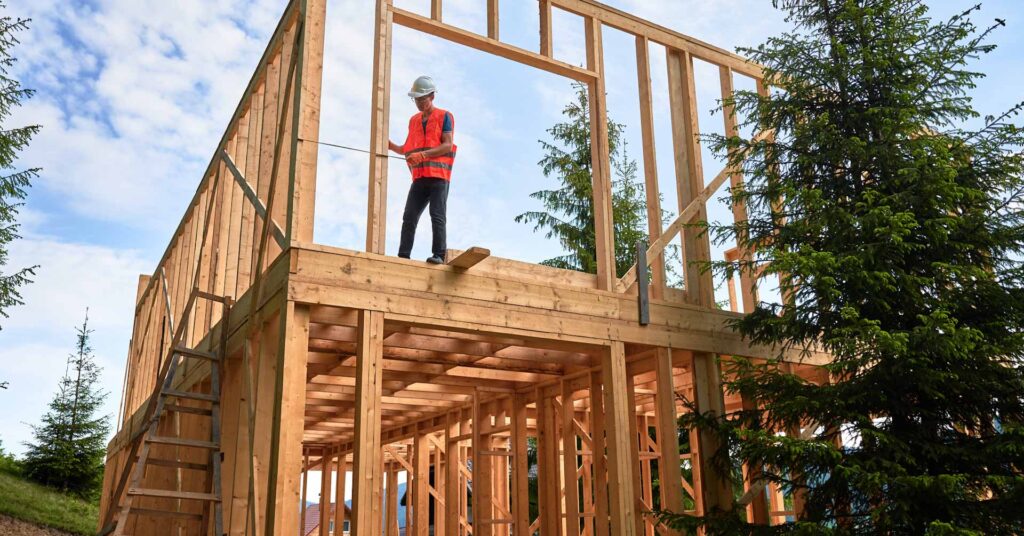 carpenter on wooden house frame