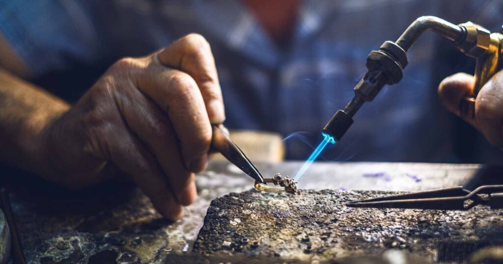 a jeweler working on a gold ring