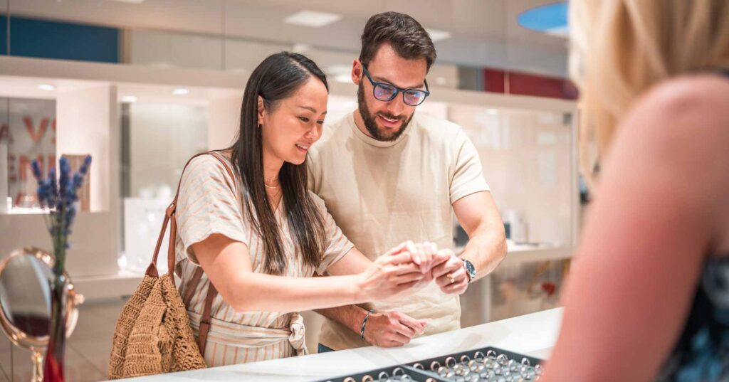 young couple shopping for rings at jewelry store