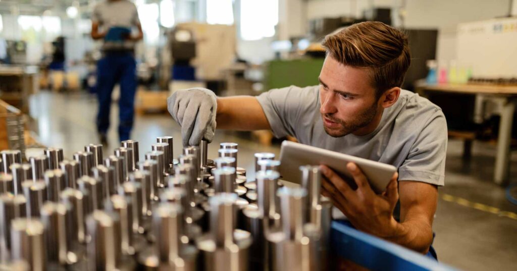 metal worker examining steel rods