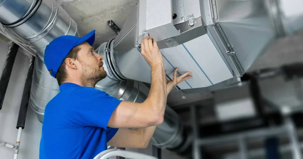 maintenance worker fixing ventilation ducts