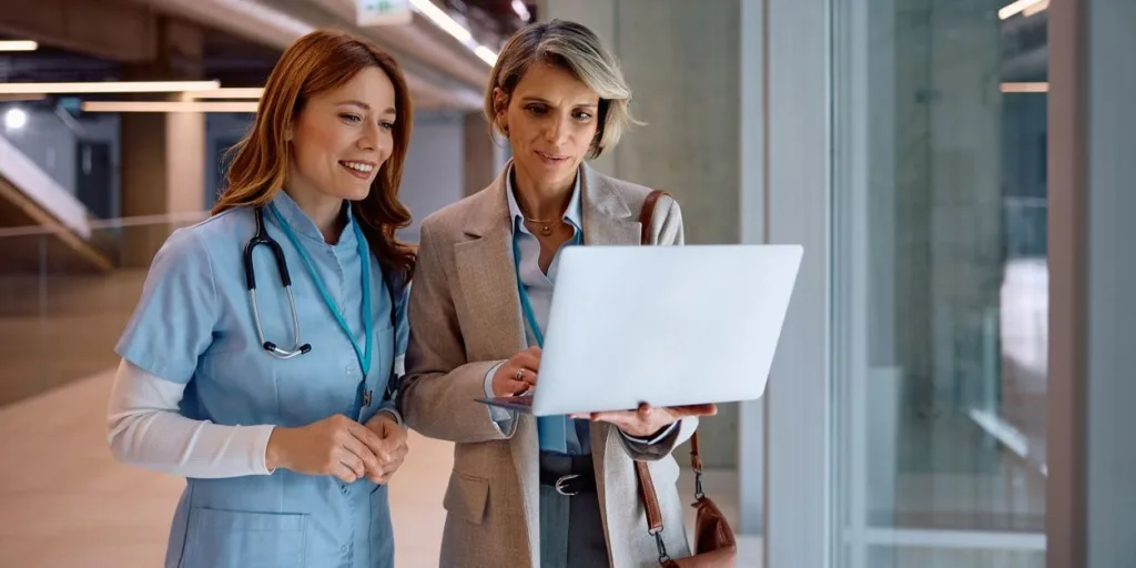medical representative speaking to a doctor looking at laptop