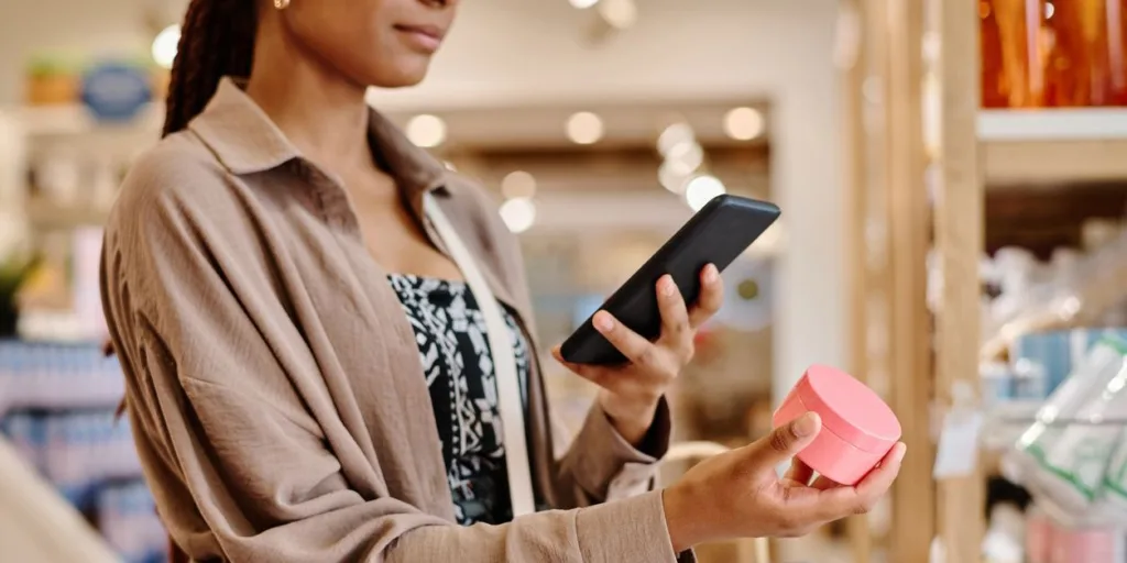 young woman taking photo of cream using smartphone