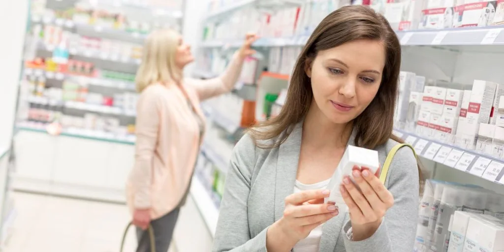 woman reading box label in health store